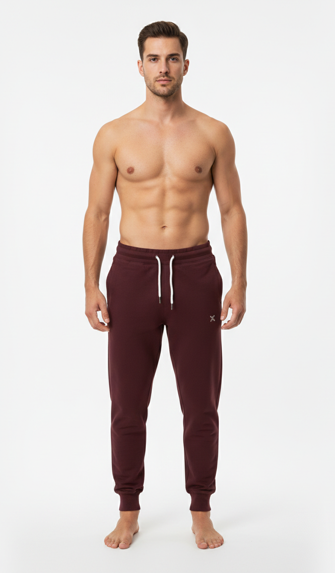 Male model wearing premium maroon athletic joggers on white background front view